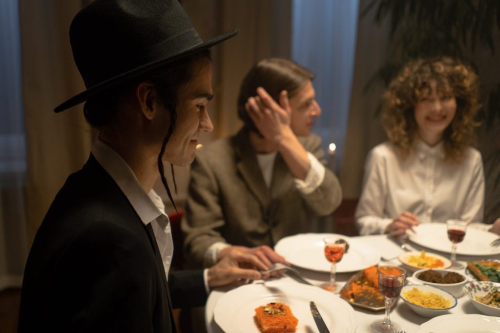 man in jewish outfit sitting at the table