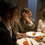 man in jewish outfit sitting at the table